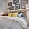 a bedroom with artwork hanging above a bed