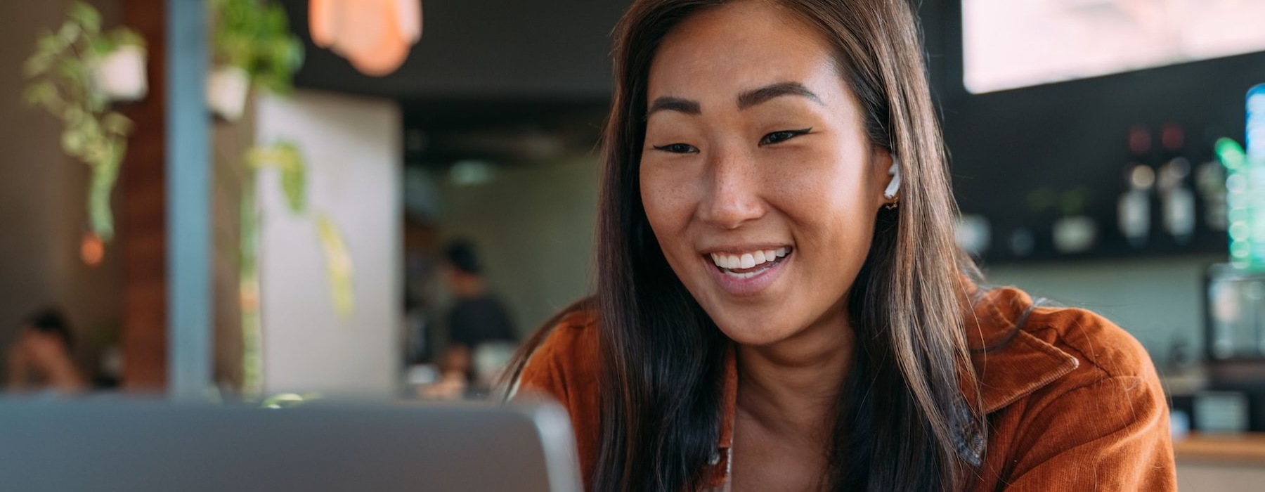 a woman smiling while working on laptop